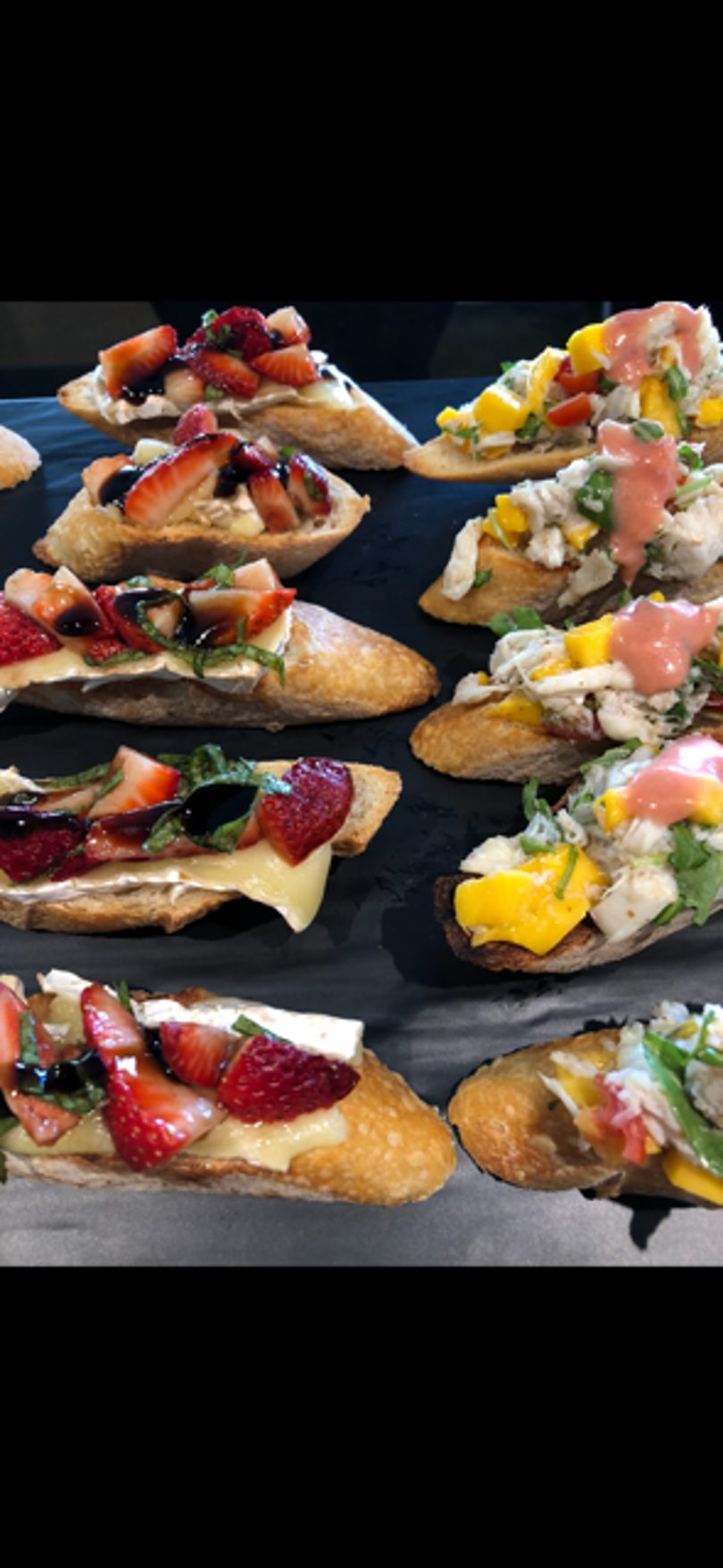 Assortment of bruschetta with strawberries and balsamic, and crab salad with mango.